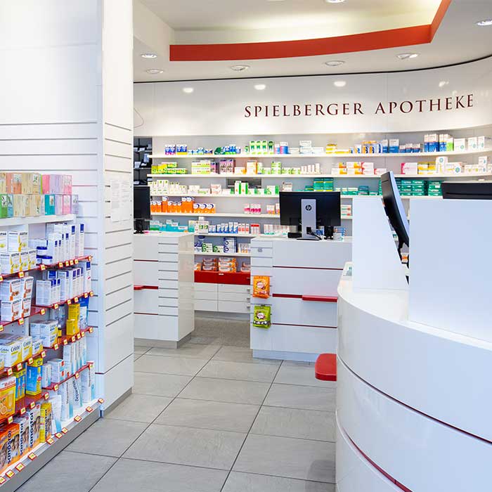 Innenraum der Spielberger Apotheke mit Regalen und runder Theke.